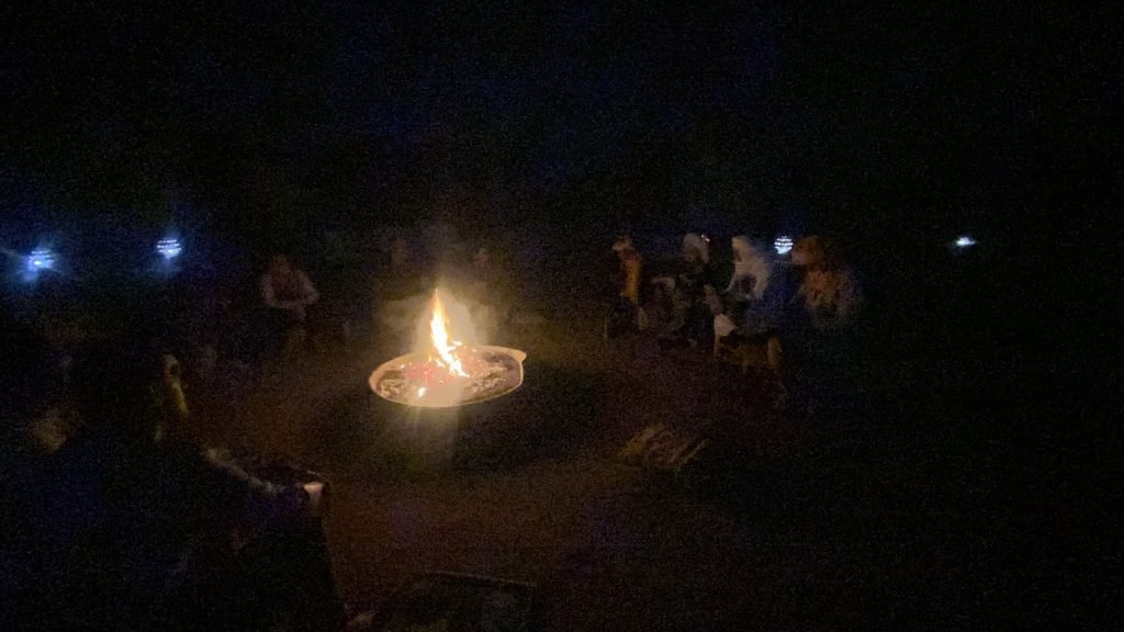 A small campfire glowing in the dark desert night